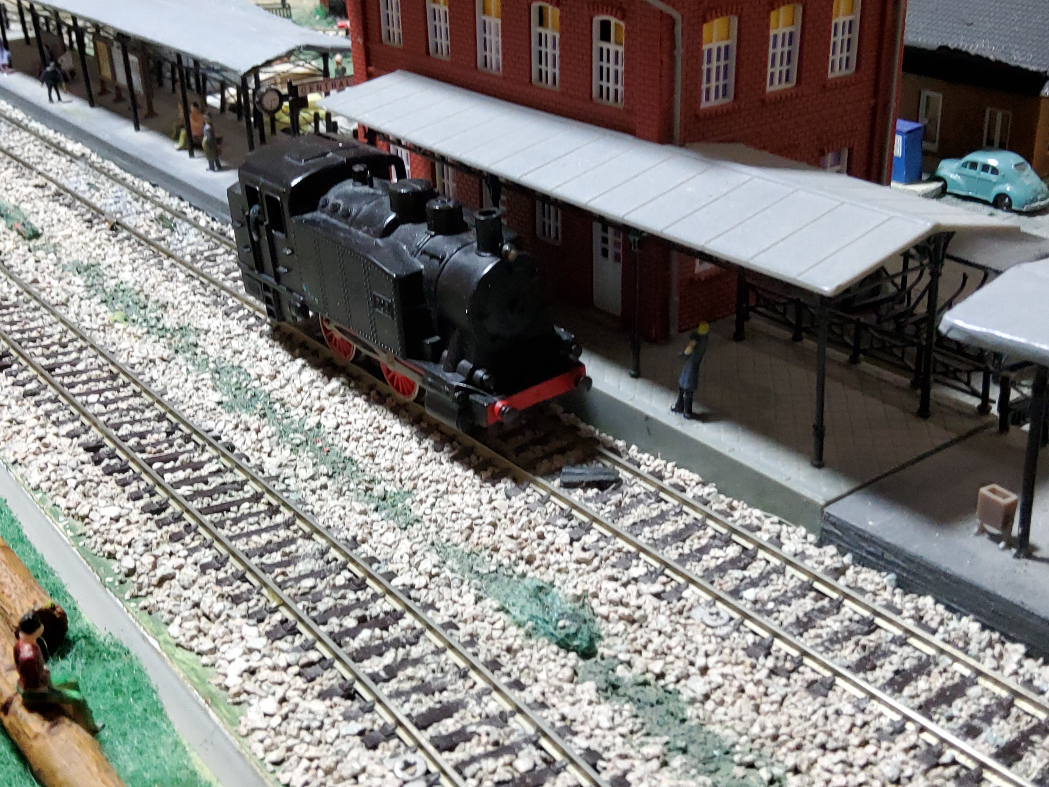 Primer plano de la locomotora tanque junto al andén de la estación