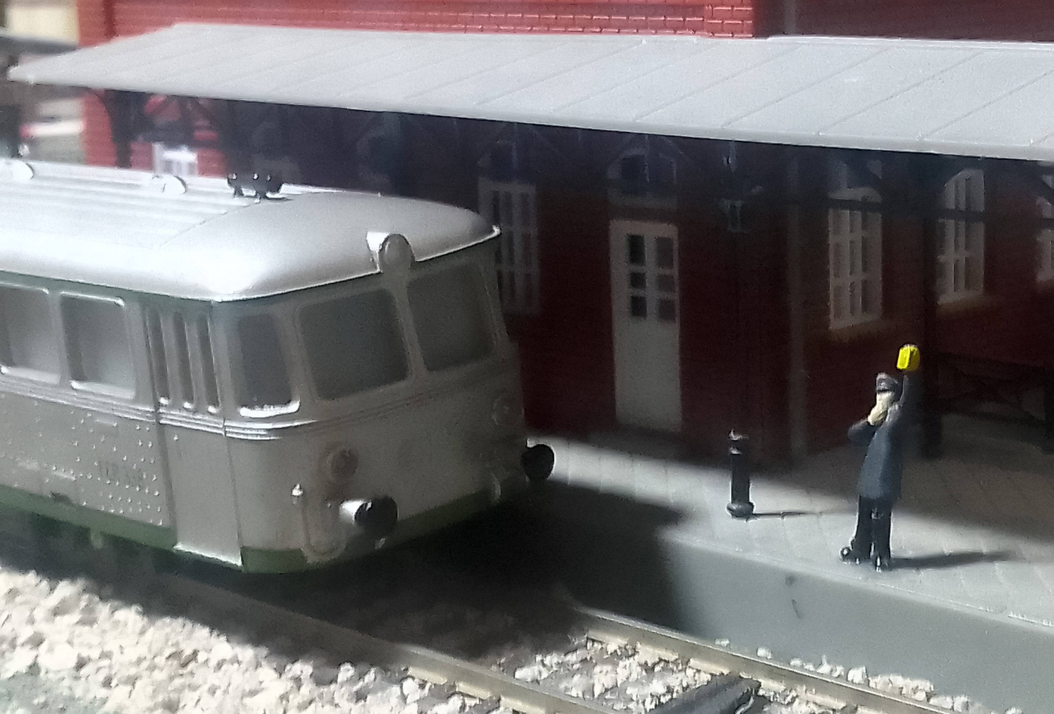 Testero del ferrobús junto al jefe de estación levantando el farol