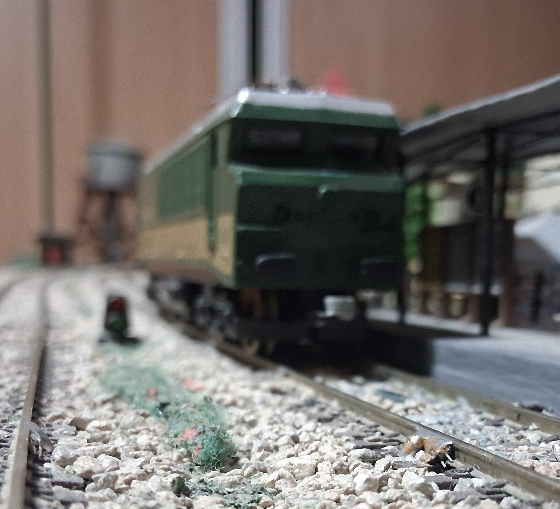 Perspectiva frontal baja de la locomotora RENFE sobre la vía del andén